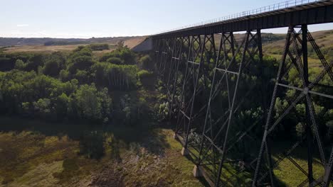 4K-Drohnenaufnahmen,-Die-Neben-Einer-Alten-Stahlbrücke-Aufsteigen-Und-Die-Landschaft-Freigeben