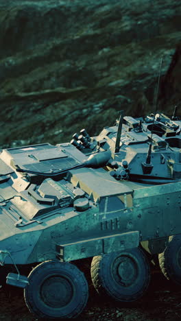 military vehicle stationed on rugged terrain under a twilight sky