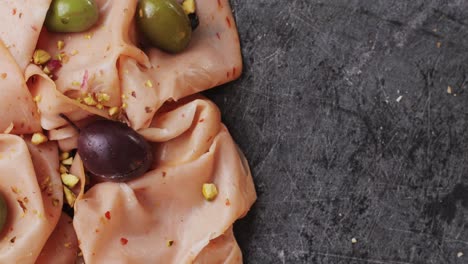 ham italian mordatella, man slices of traditional italian antipasti mortadella sausage on a wooden cutting board, close up macro of chicken or turkey jamon, fat breakfast dish.