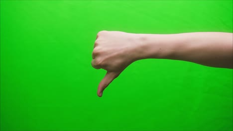 close-up of a hand gesture on a green background, dislike gesture, shooting a gesturing in studio