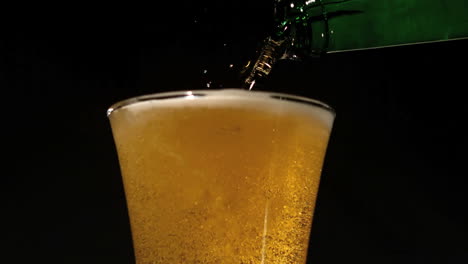 bottle pouring beer into glass