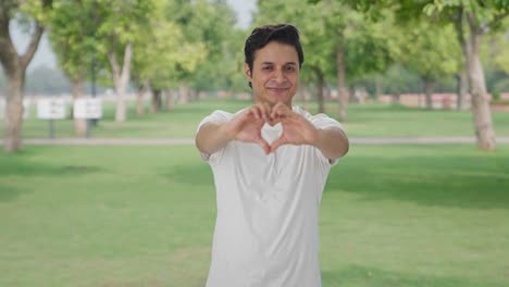 happy indian man showing heart sign