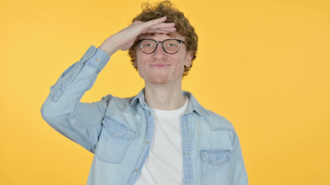 un joven pelirrojo en busca de oportunidades, fondo amarillo