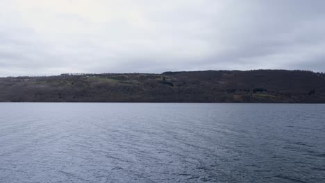 Mirando-A-Través-Del-Agua-Del-Lago-Ness-Hacia-El-Otro-Lado-Del-Lago-En-Las-Tierras-Altas-De-Escocia,-Reino-Unido