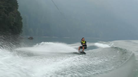 front view of caucasian young man doing tricks on wakeboard in the city river 4k