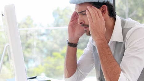 frustrated hipster businessman using his laptop