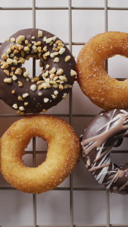 video of donuts with sprinkles on baking rack on white background