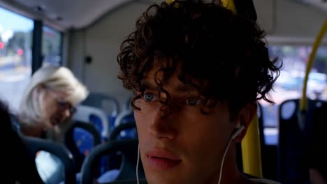 -Male-commuter-listening-music-on-earphones-while-travelling-in-bus-4k
