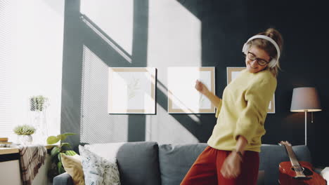 woman in headphones dancing at home