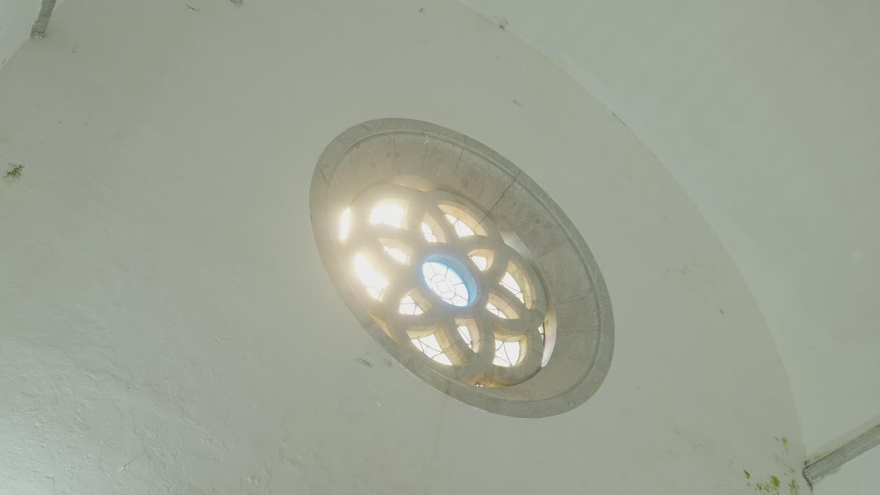 Warm sunlight filtering through an ornate circular stained glass window inside an old church