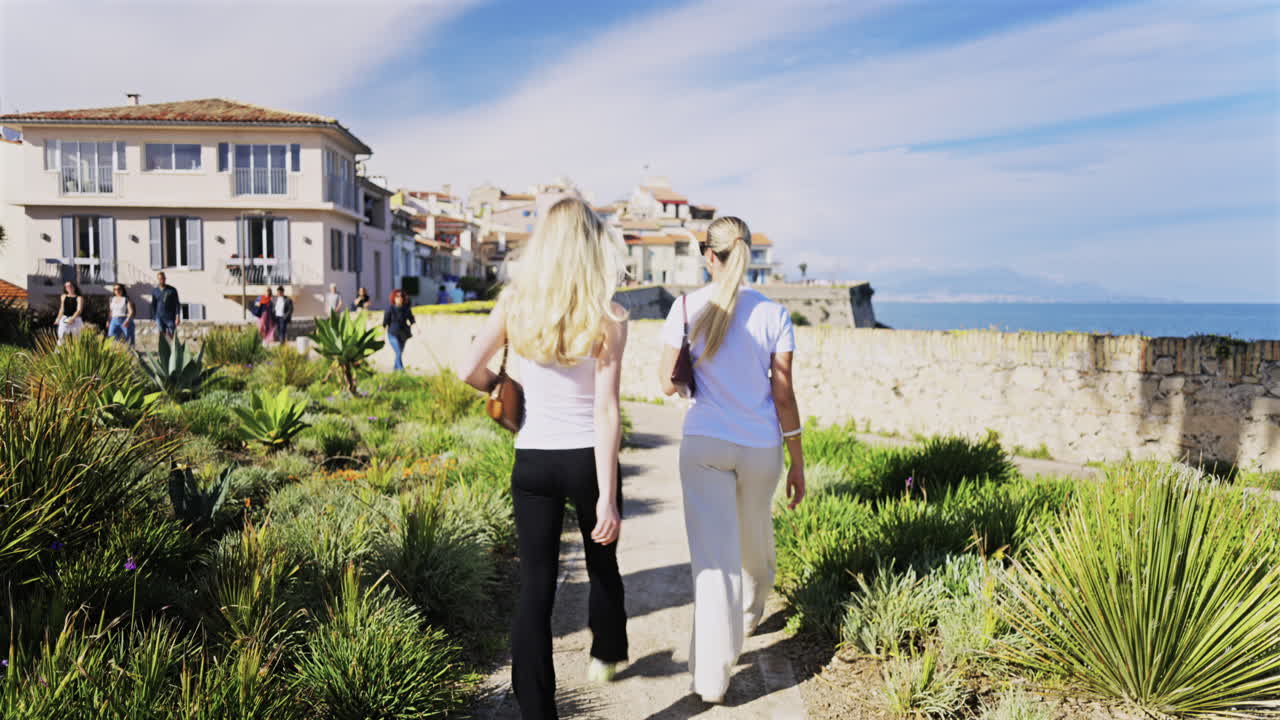 Antibes, France - April 27, 2025: View of people walking near different buildings on the coast