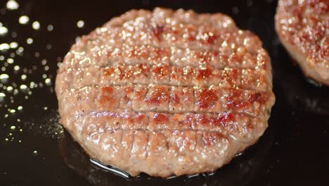 fried burger of fresh beef in a frying pan in oil.