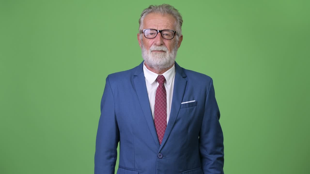 Affascinante uomo d'affari anziano con barba su sfondo verde