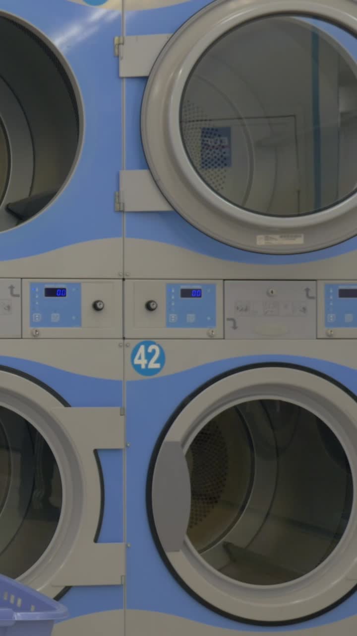 Industrial Washing Machine Doors Opening and Closing in Laundromat