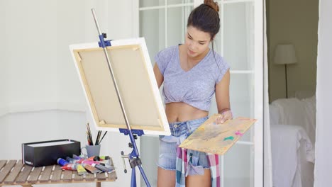 artistic young woman working on a painting