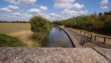 Wide-shot-from-Aston-Lock-looking-down-on-to-Trent-and-Mersey-Canal-with-stone-bridge-walls-in-foreground