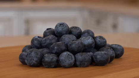 close up of several blueberrie berries. rotating camera with white kitchen on the background. dolly-shot.
