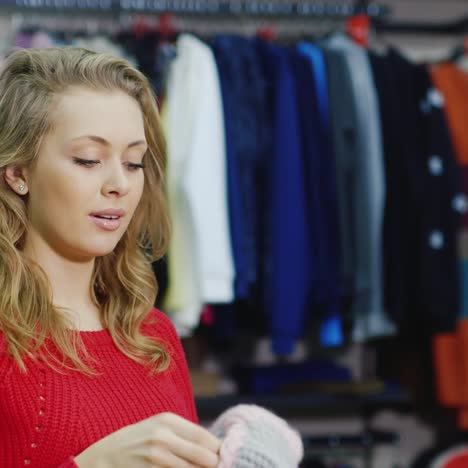 attractive woman in a red sweater tries warm mittens