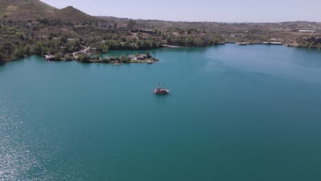 vista of alanya pirate boat across green lake in oymapinar dam area, antalya, turkey