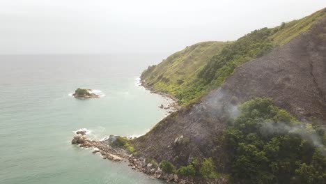 la ladera de la montaña en círculo aéreo se ve poco después del incendio, el humo se eleva desde el área quemada
