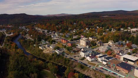 aerial shot of a quiet new england town surrounded by fall color landscape