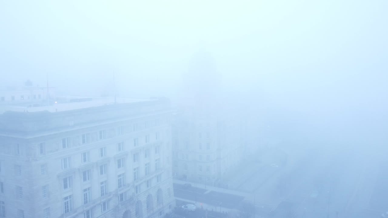 리버풀 시를 가로지르는 짙은 짙은 유령 안개 덮개 초현실적인 시내 해안가 전방 하강의 공중 전망