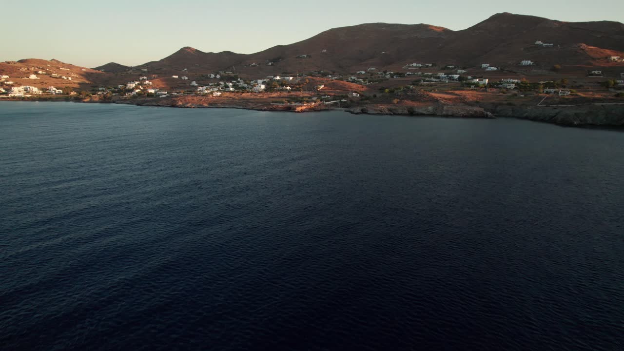 drone dolly tilt hasta la ciudad costera de syros grecia al atardecer, espacio para el texto