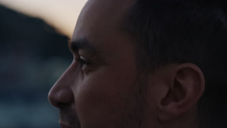 close-up-portrait-attractive-young-caucasian-man-on-rooftop-at-sunset-chatting-enjoying-conversation-with-bokeh-city-lights-in-background