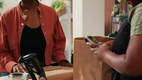 mujer pagando por productos a granel con tarjeta en pos