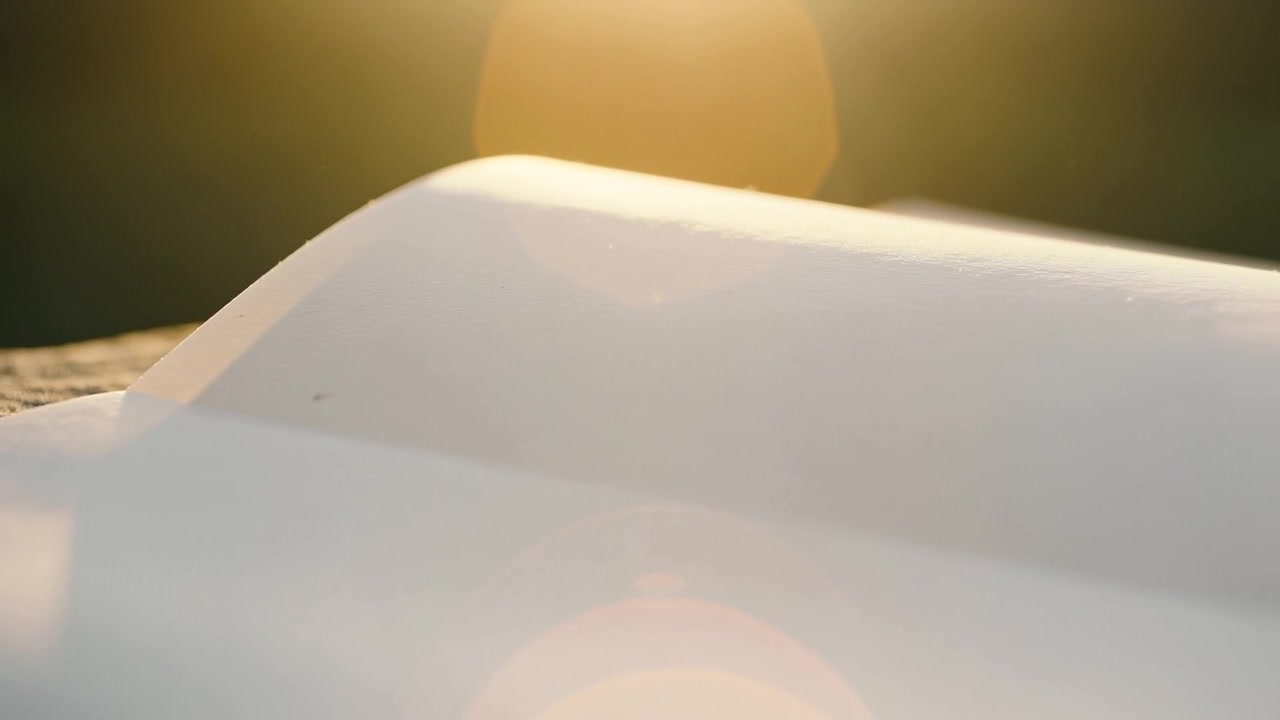 Showing white contoured object shifting rim glow on textured base at sunset, sun causing flares