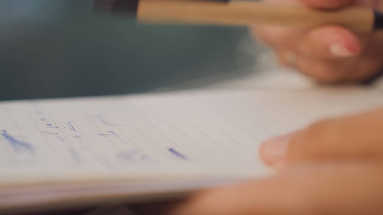 Handwritten note editing. Focusing on precise edits of handwritten pages with ink marks present. Carefully marking and correcting handwritten notes on lined pages during manuscript revision
