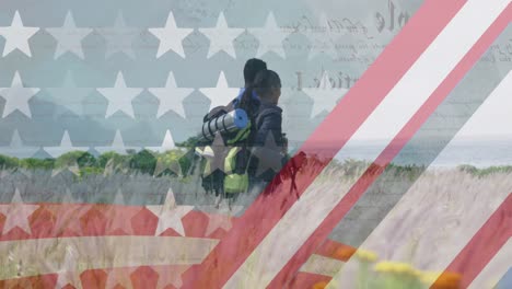 Animation-of-american-flag-over-diverse-couple-hiking-in-mountains