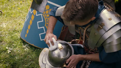 roman soldier cleaning his helmet