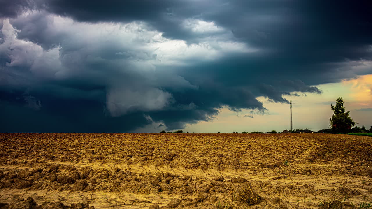 Mørkt, stormfuldt skydække time lapse i landbrugslandskabet