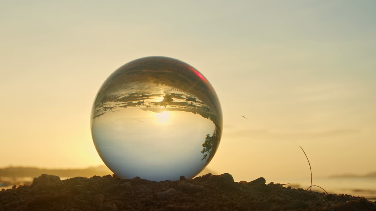 vista mágica del atardecer en la playa en una bola de cristal.