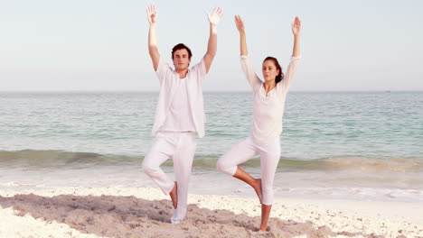 una pareja tranquila meditando en la playa.
