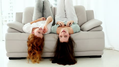 Two-lovely-women-lying-head-first-on-couch