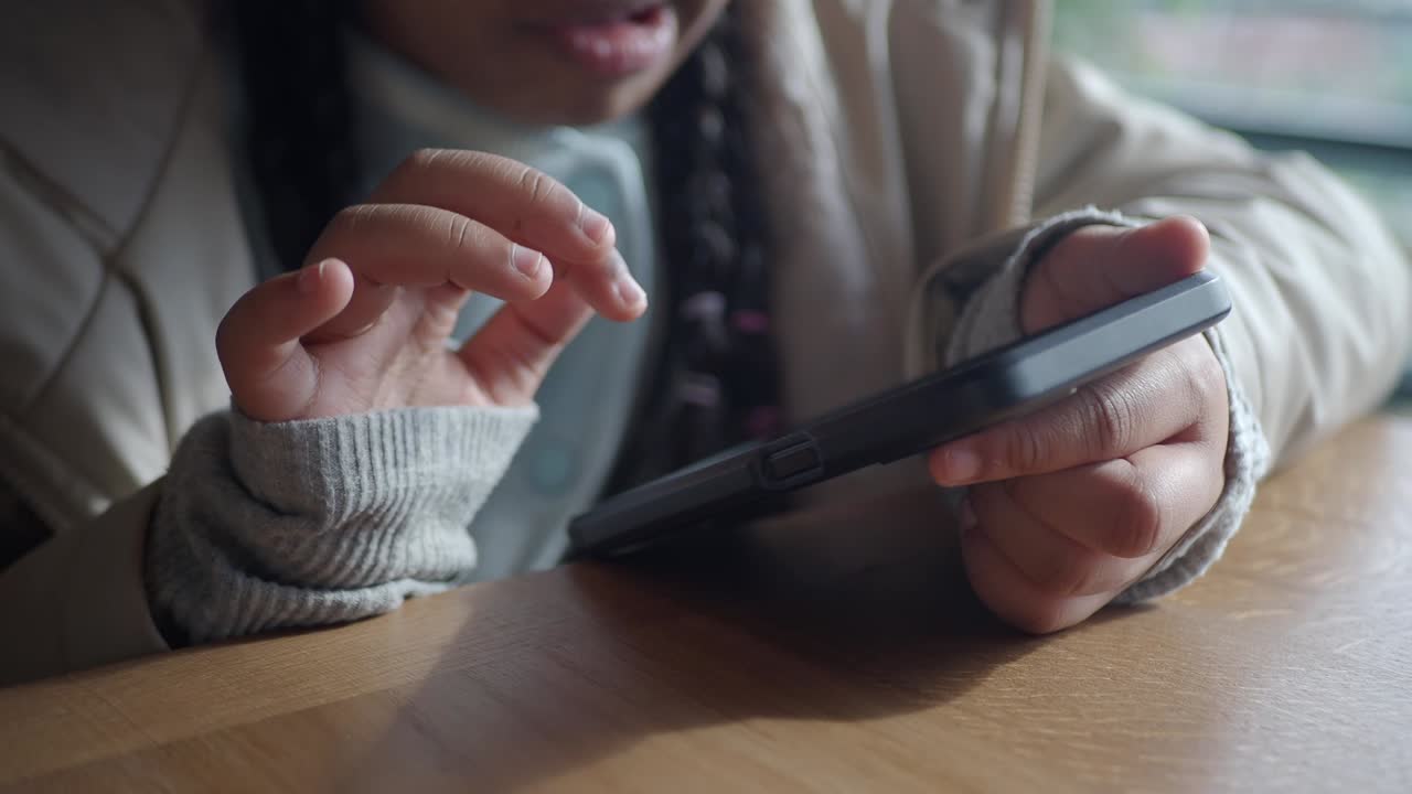 Close-Up of Child's Hands Tapping and Swiping on a Smartphone