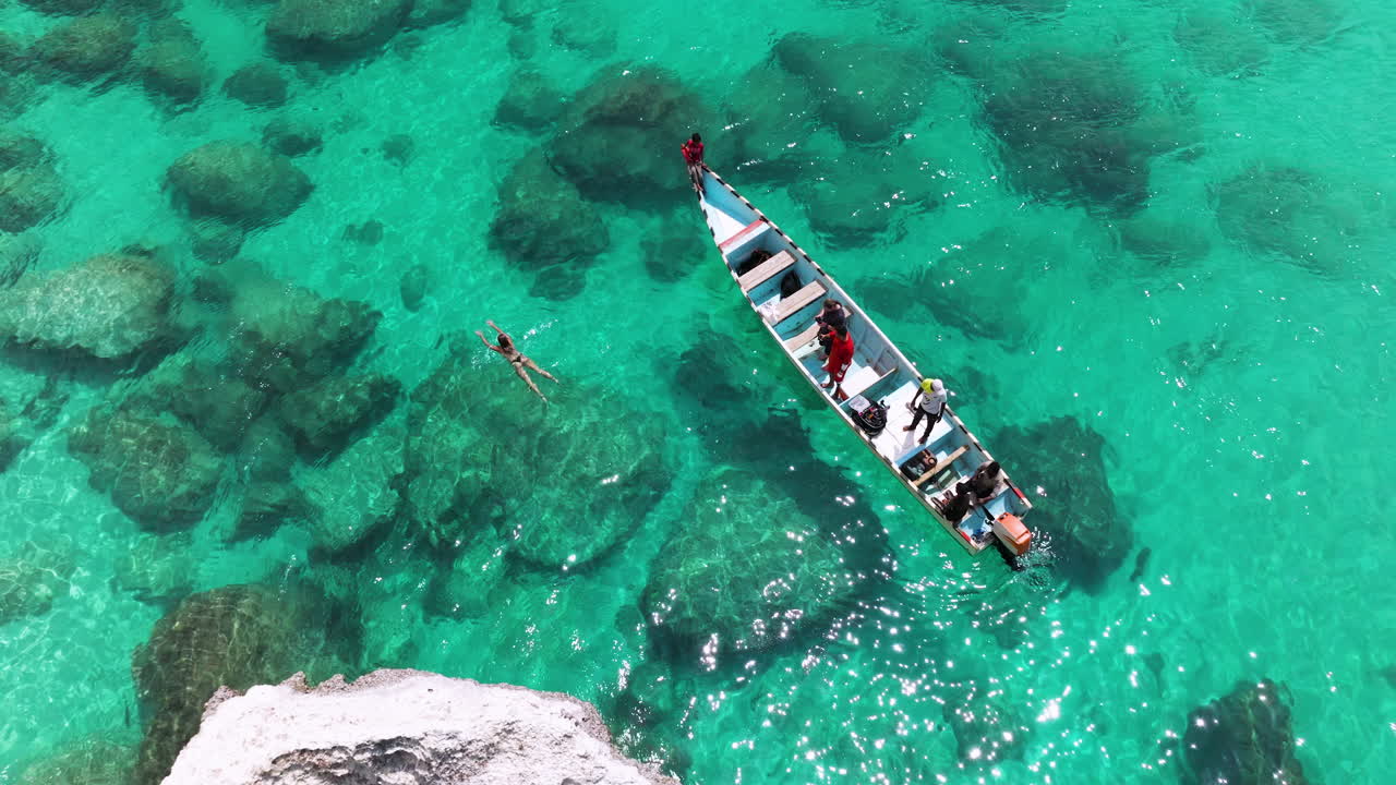 Aerial View Of Woman Swimming In The Clear Water Next To The Boat In Socotra Island, Yemen
