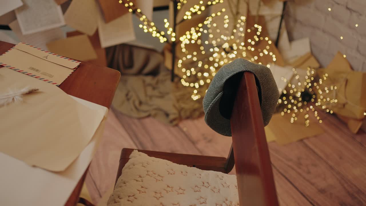 Christmas themed desk with mail, a hat, and festive lights in a cozy corner - slow mo