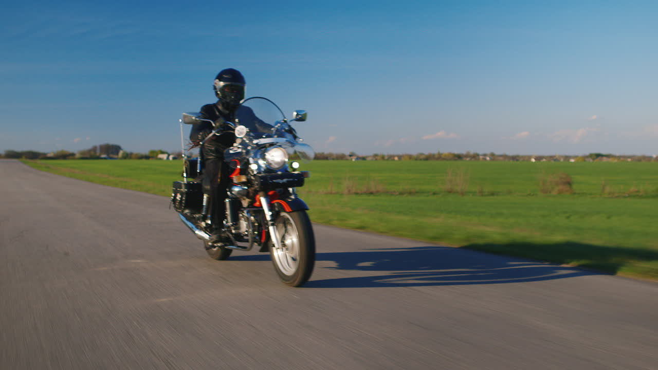 도로 위의 짧은 서사시 - 흔들리는 슬릭 없이 녹색 필드의 부드러운 움직임을 배경으로 자전거 타기