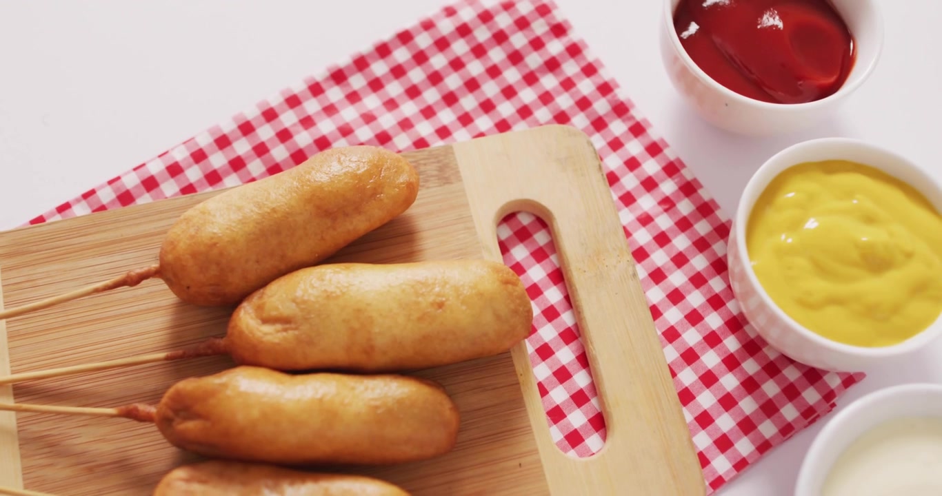Icona blu del 'mi piace' che appare a sinistra, generando altre icone che fluttuano sopra dei corn dog, mostrando un aumento dei 'mi piace'.