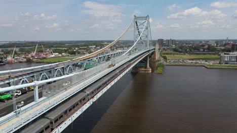 Drohnenansicht-Des-Patco-Speedline-Zugs,-Der-Die-Ben-Franklin-Brücke-Von-Philadelphia-Nach-New-Jersey-überquert,-Aufnahme-Auf-DJI-Mavic-Air-2-In-4K,-Farbe-Ist-D-Cinelike-Aufnahme-In-29