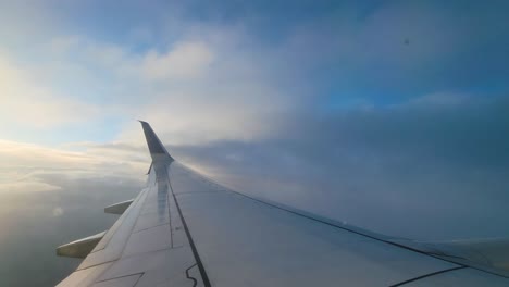 pov from airplane window, flying through white and fluffy clouds in the sky