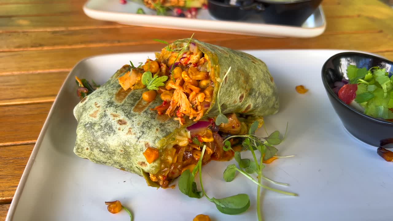 delicioso envoltorio de pollo saludable con verduras y ensalada en marbella españa, brunch en un restaurante, tiro de 4k