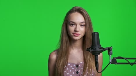 una adolescente sonriente hablando en el micrófono.