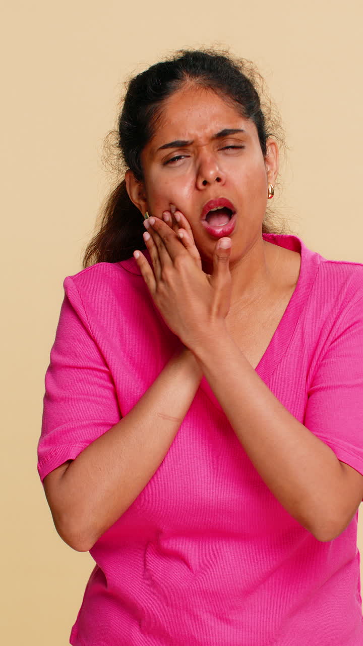Indian woman touching cheek with visible discomfort clearly experiencing strong toothache pain