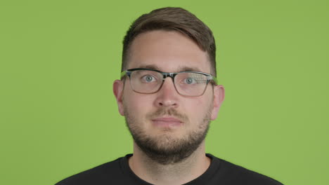 el hombre con anteojos se quita la máscara protectora kn95 mientras mira a la cámara en la pantalla verde chroma key close up