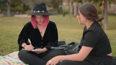 two women discussing ideas in a park
