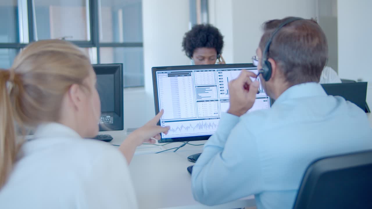 Mentor teaching employee to work with financial data